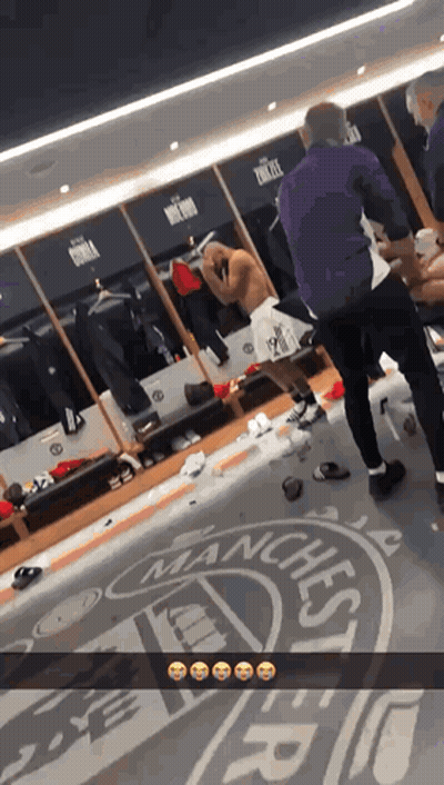Man Standing In Locker Room With Manchester Logo GIF