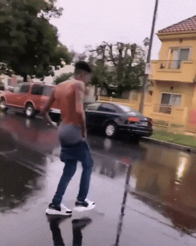 Man Standing In Puddle On Wet Street GIF