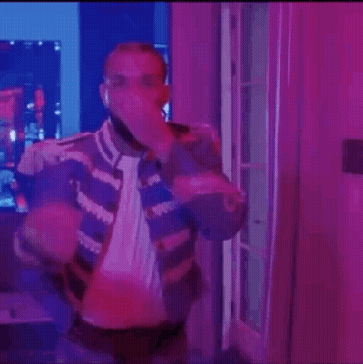 Man Standing In Purple Lit Room With Microphone GIF
