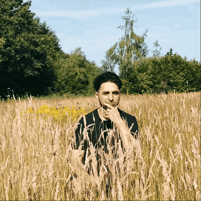 Man Standing In Tall Grass GIF