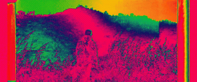Man Standing In Tall Grass Colorful Thermal Image GIF