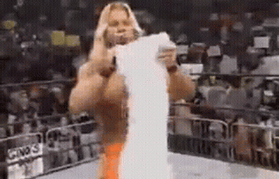Man Standing In Wrestling Ring Holding Paper GIF