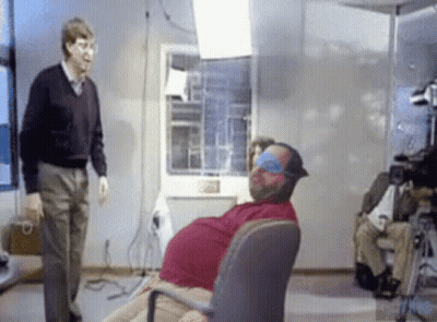 Man Standing Next To Blindfolded Man In Chair GIF