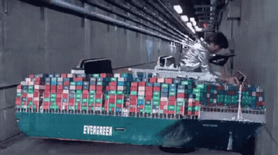 Man Standing Next To Container Ship In Tunnel GIF