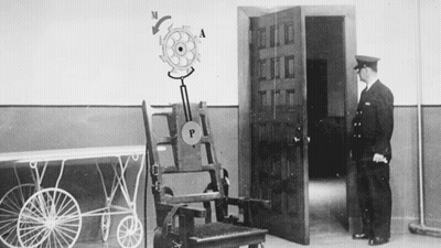 Man Standing Next To Electric Chair GIF