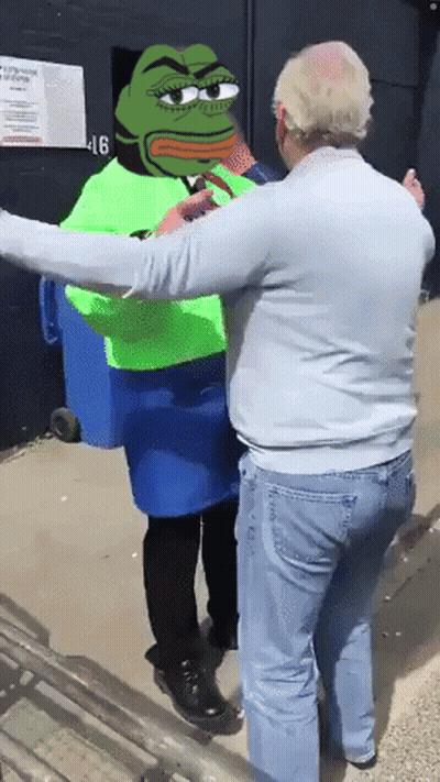 Man Standing Next To Frog In Green Vest GIF