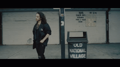 Man Standing Next To Old National Village Garbage Can GIF
