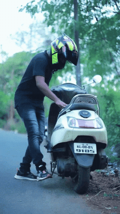 Man Standing Next To Scooter With License Plate KL DB BN 9185 GIF
