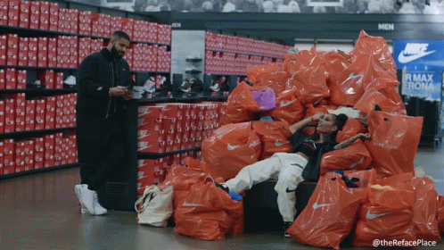 Man Standing Next To Woman On Nike Bags GIF