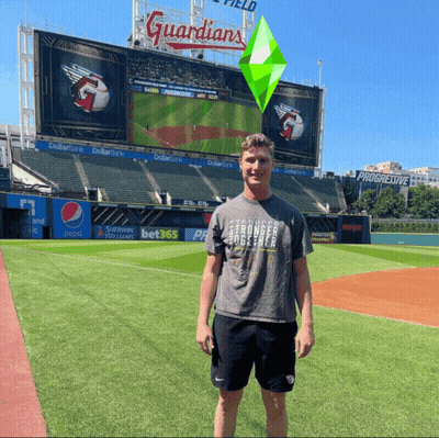 Man Standing On Baseball Field In Front Of Guardians Sign GIF