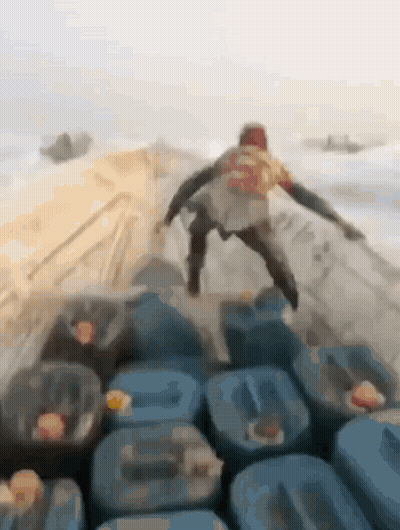 Man Standing On Blue Barrels GIF