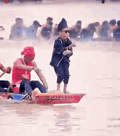 Man Standing On Boat As People Row GIF