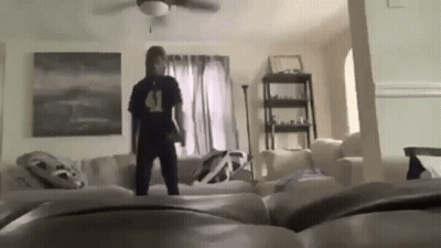 Man Standing On Couch In Living Room GIF