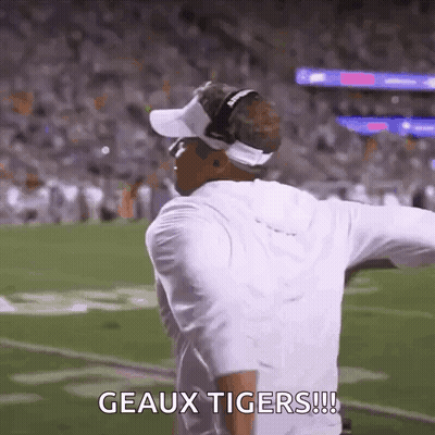 Man Standing On Football Field With Arms Outstretched Says Geaux Tigers GIF