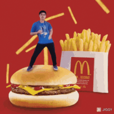 Man Standing On McDonald's Hamburger Next To Fries GIF