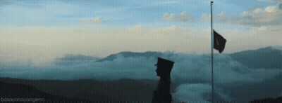 Man Standing On Mountain With Flag GIF