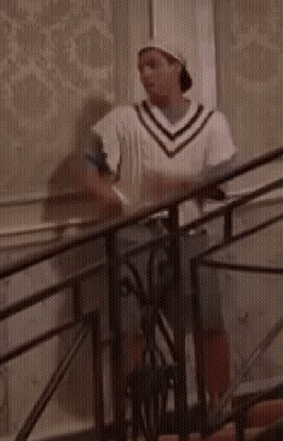 Man Standing On Stairs In Hat And White Sweater GIF