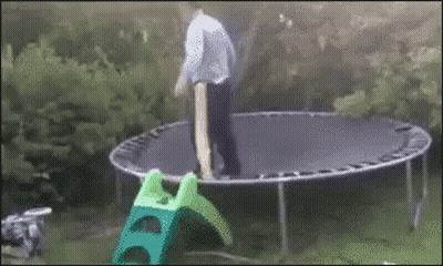 Man Standing On Trampoline Next To Green Slide GIF