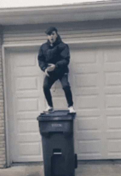Man Standing On Trash Can In Front Of Garage Door GIF