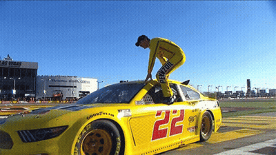 Man Standing On Yellow Race Car Number 22 GIF