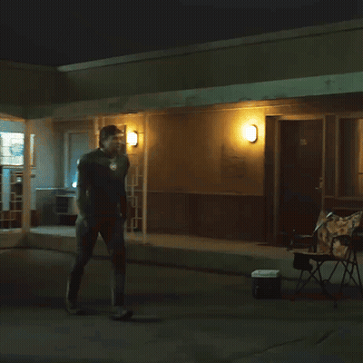 Man Standing Outside Building With Wall Light GIF