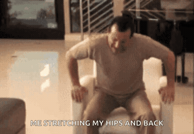 Man Stretching Hips And Back In Chair GIF