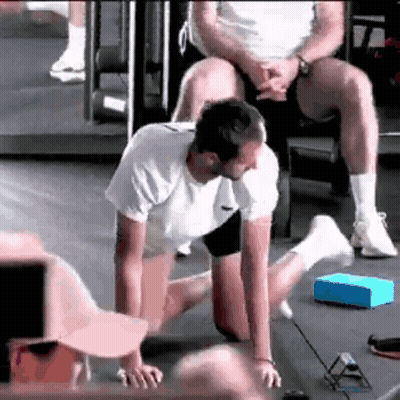 Man Stretching In Gym With Man On Lap GIF