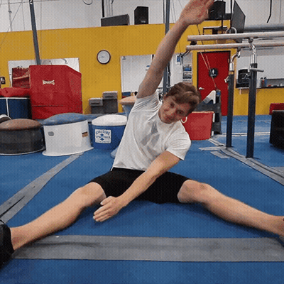 Man Stretching Legs In Gym With Ice Cold Water Cooler GIF