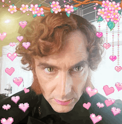 Man Surrounded By Hearts And Flowers GIF