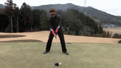 Man Swinging At Ball On Golf Course GIF
