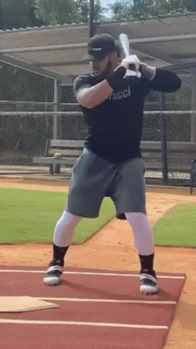 Man Swinging Bat On Baseball Field GIF