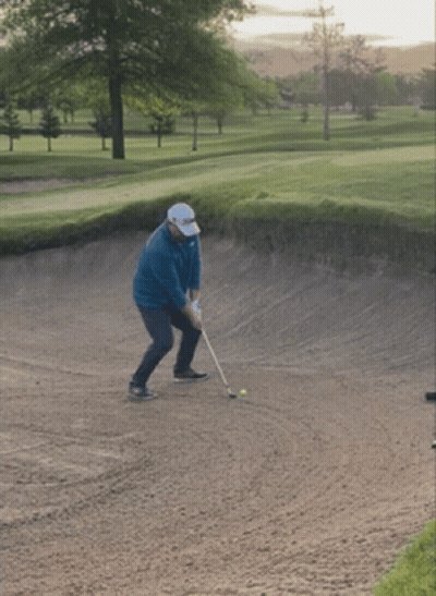 Man Swinging Golf Club At Ball In Bunker GIF