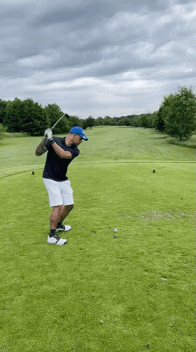 Man Swinging Golf Club At Ball GIF