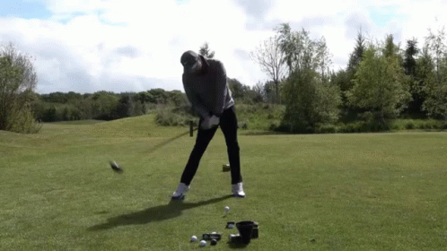 Man Swinging Golf Club At Golf Ball GIF