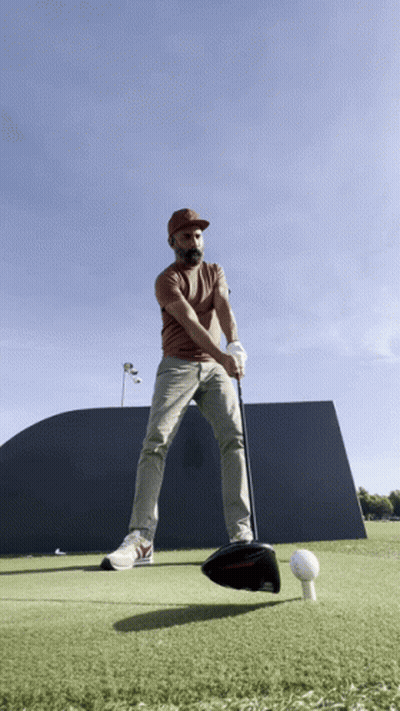 Man Swinging Golf Club At Golf Ball GIF