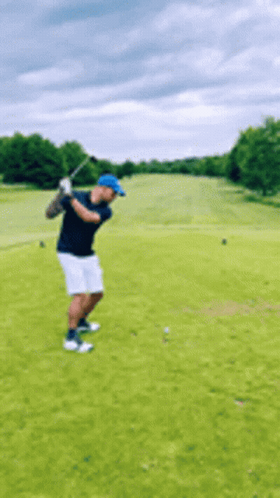 Man Swinging Golf Club At Golf Ball On Golf Course GIF