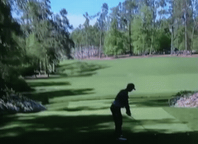 Man Swinging Golf Club at Green