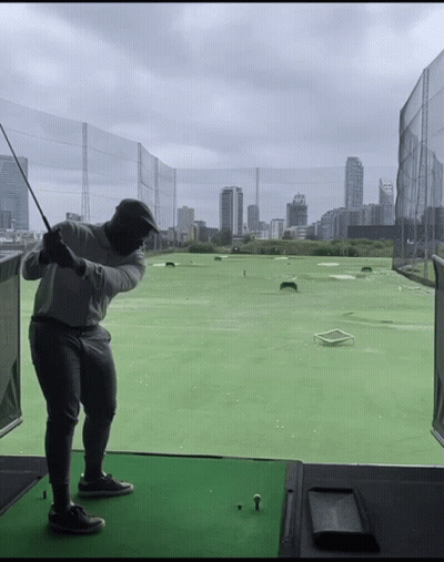 Man Swinging Golf Club City Background GIF