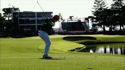Man Swinging Golf Club in Front of Tokyo 2020 Building
