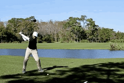 Man Swinging Golf Club Near Pond GIF