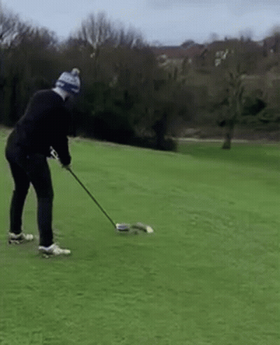 Man Swinging Golf Club On Green Field GIF