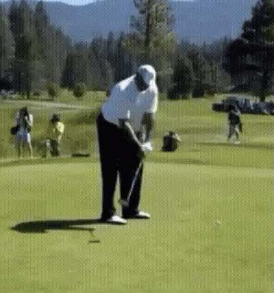 Man Swinging Golf Club While People Watch GIF