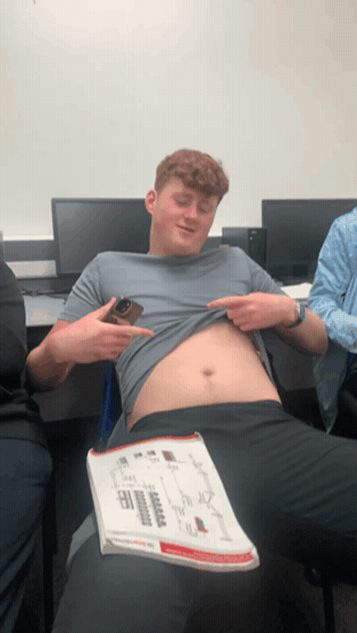 Man Taking Off Shirt Holding Book GIF