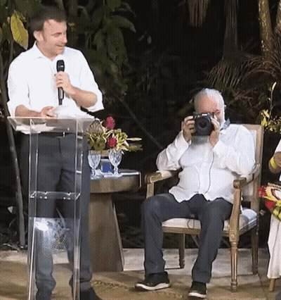 Man Taking Picture At Podium With Microphone GIF