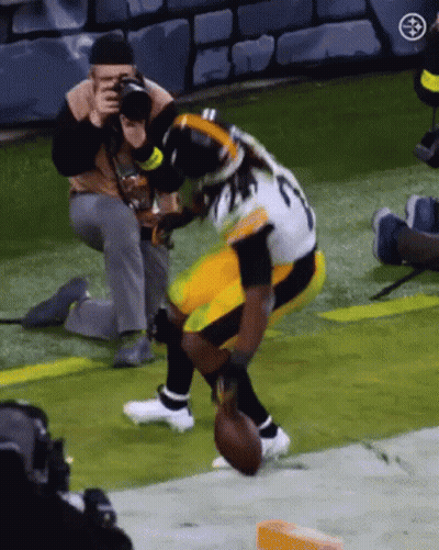 Man Taking Picture Of Football Player Holding Football GIF