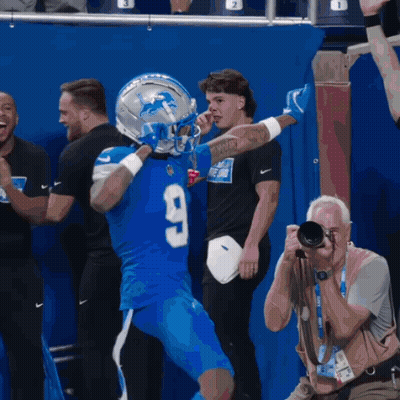 Man Taking Picture Of Football Player In Number 9 Jersey GIF