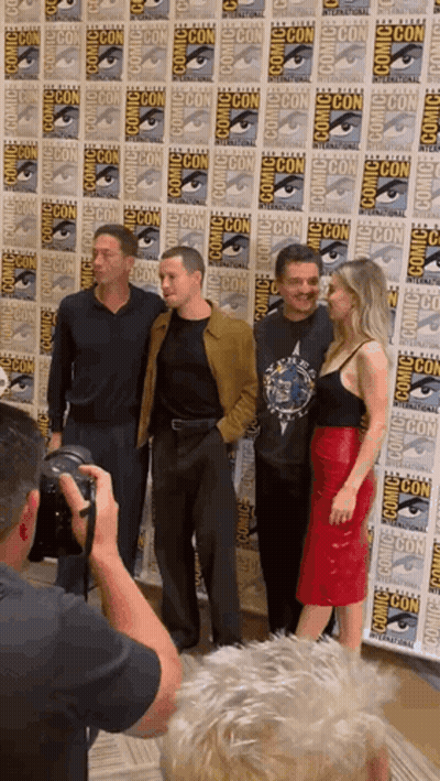 Man Taking Picture Of Group In Front Of Comic Con Wall GIF