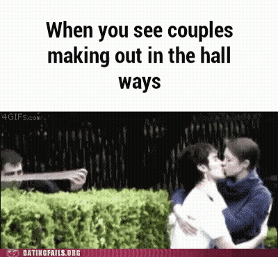Man Taking Picture Of Kissing Couple In Hallway GIF