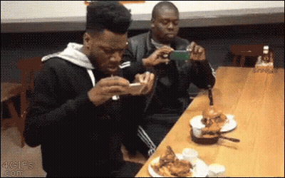 Man Taking Picture Of Man Eating Hamburger GIF