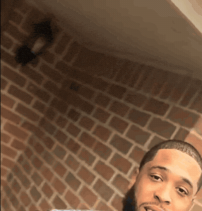 Man Taking Selfie In Front Of Brick Wall GIF